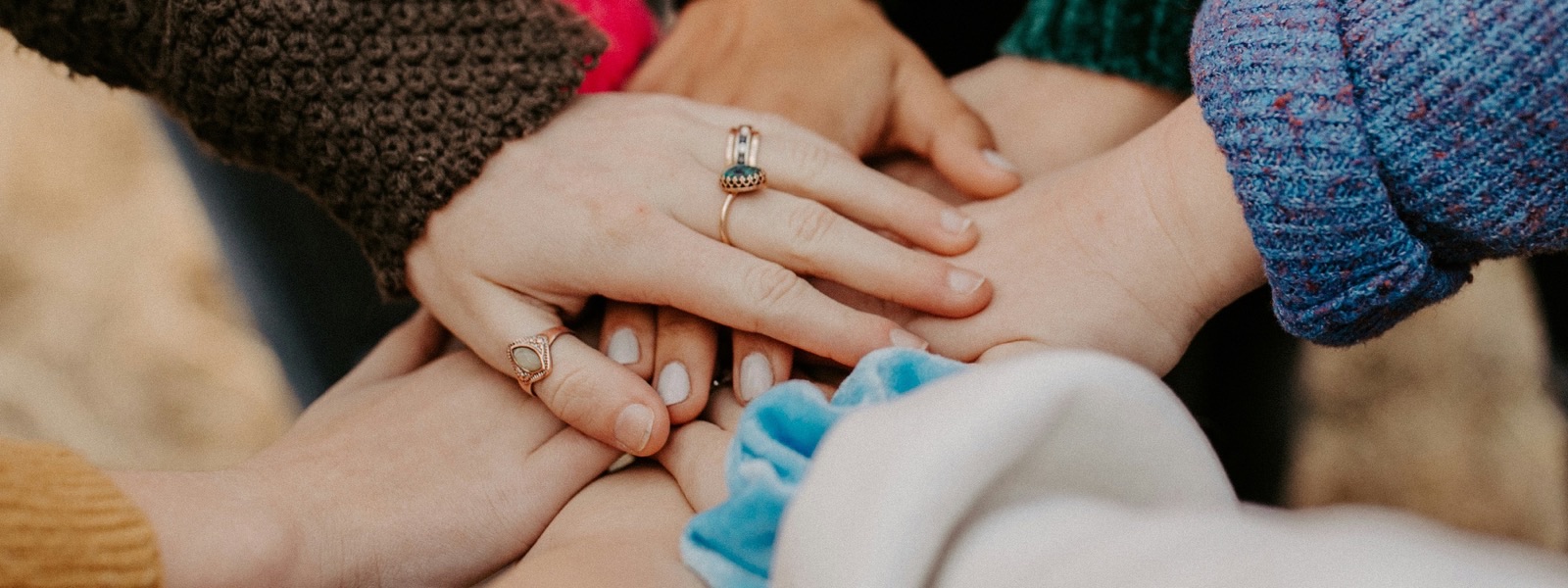 Handen van meerdere vrouwen op elkaar — samenwerking binnen het consortium